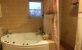 Ванная комната с джакузи и кедровой бочкой в левой половине коттеджа
